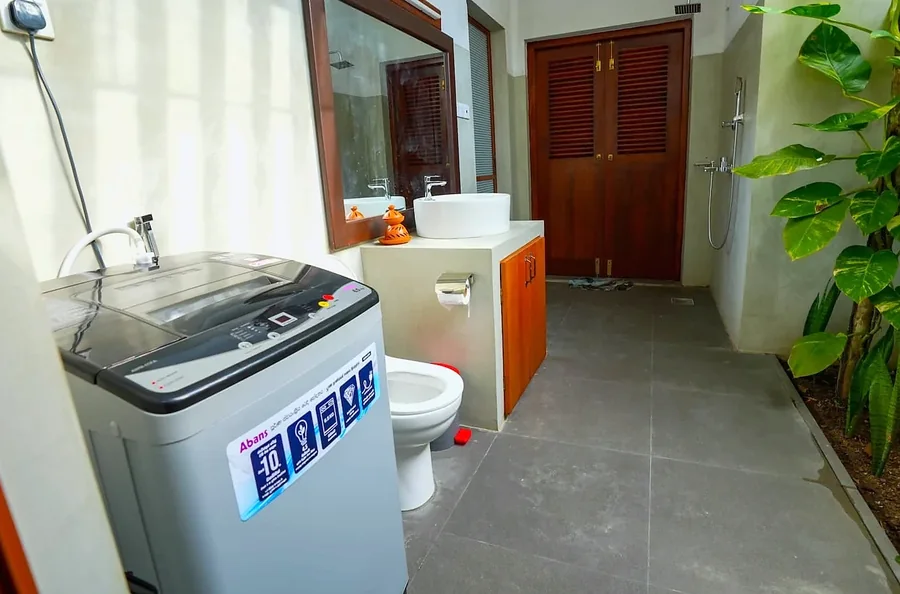 Bathroom and laundry area with a washing machine — Syndeo Garden, Hikkaduwa
