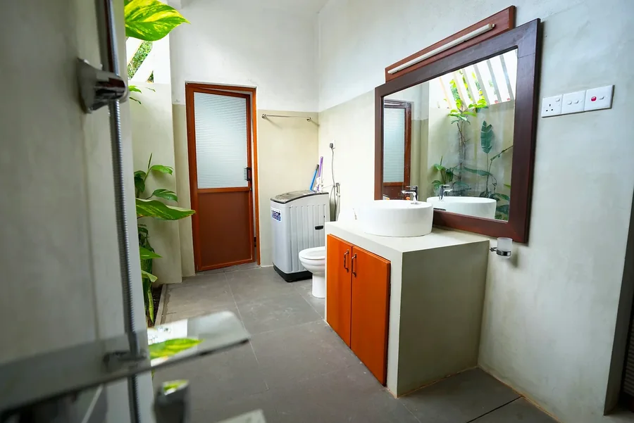 Bathroom with a wooden vanity and garden-side window — Syndeo Garden, Hikkaduwa