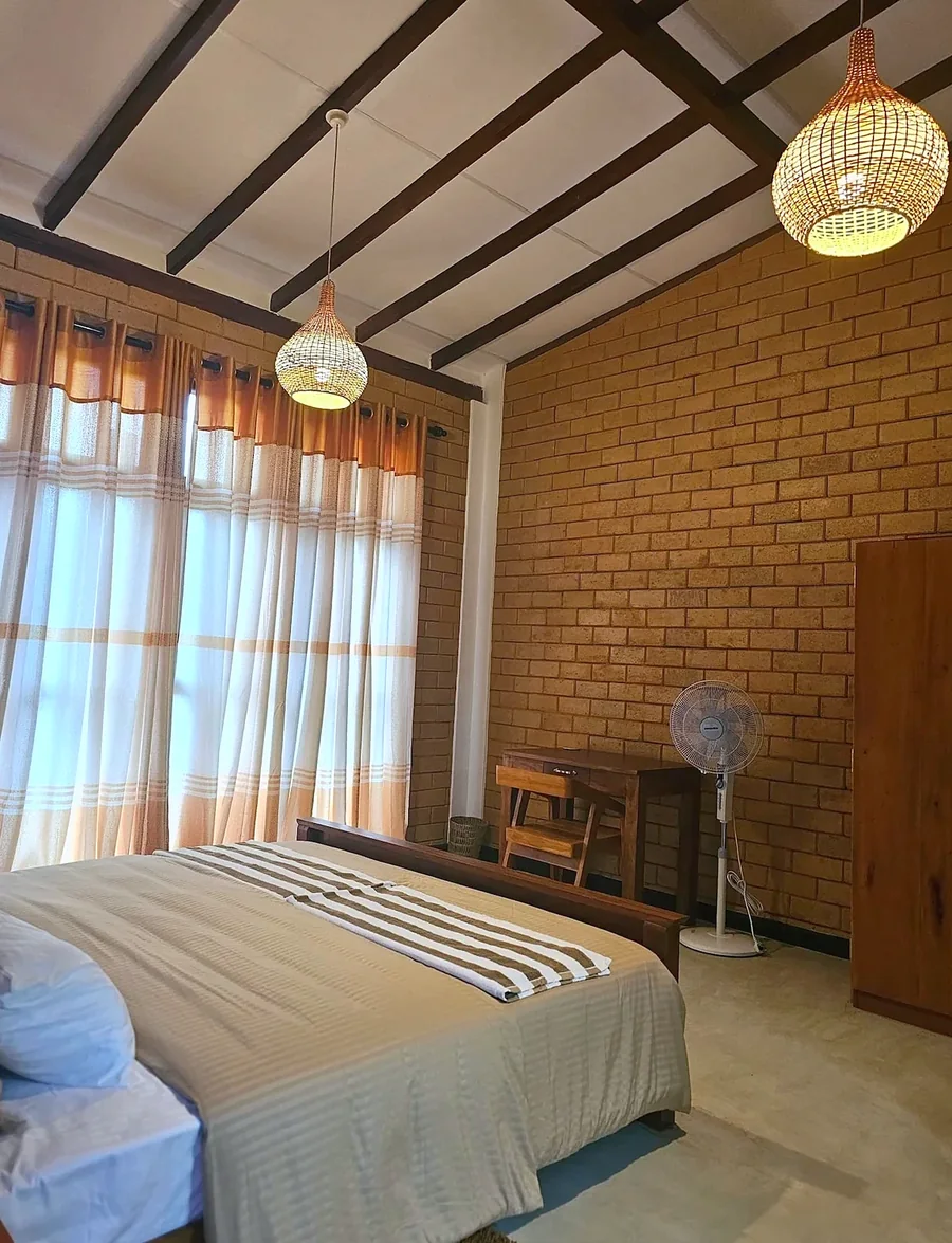 Bedroom with striped linen and brick walls — Syndeo Garden, Hikkaduwa