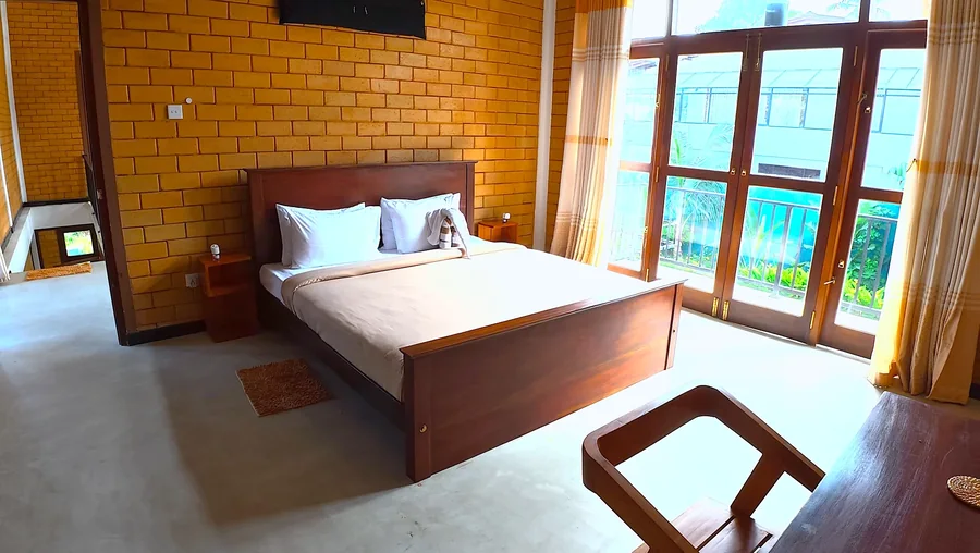Bedroom with tall garden-facing windows — Syndeo Garden, Hikkaduwa