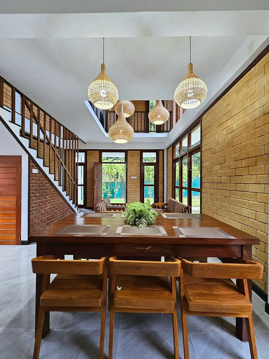 Dining area beside tall garden-facing windows — Syndeo Garden, Hikkaduwa