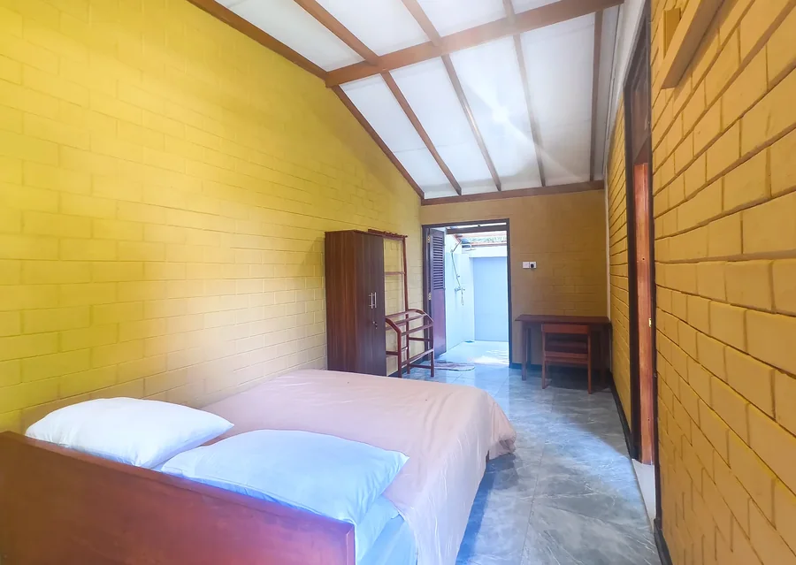 Ground-floor bedroom with wooden furniture — Syndeo Garden, Hikkaduwa