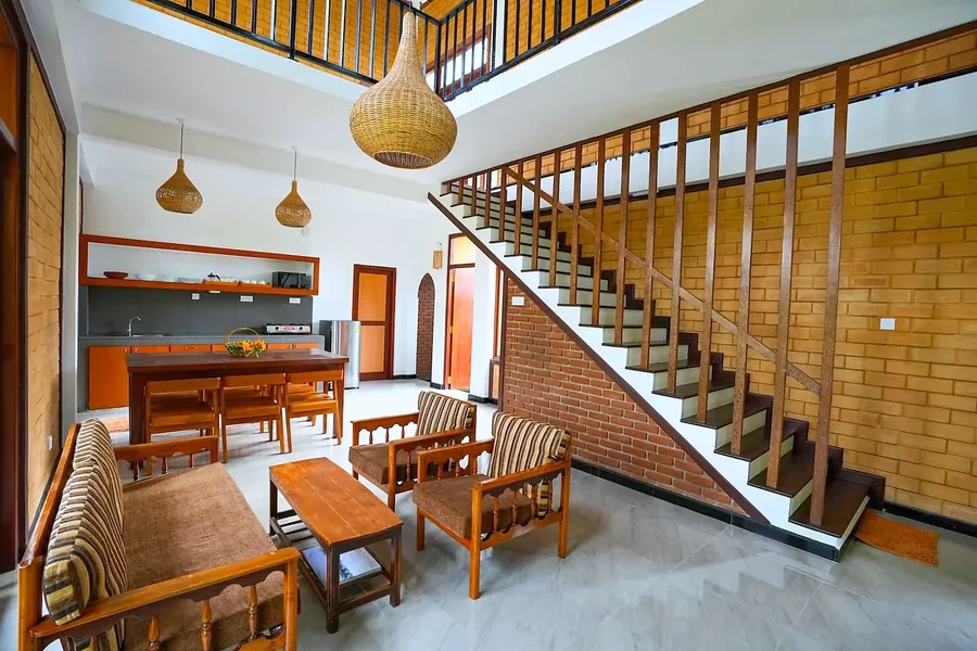 Spacious living and dining area with a wooden staircase — Syndeo Garden, Hikkaduwa