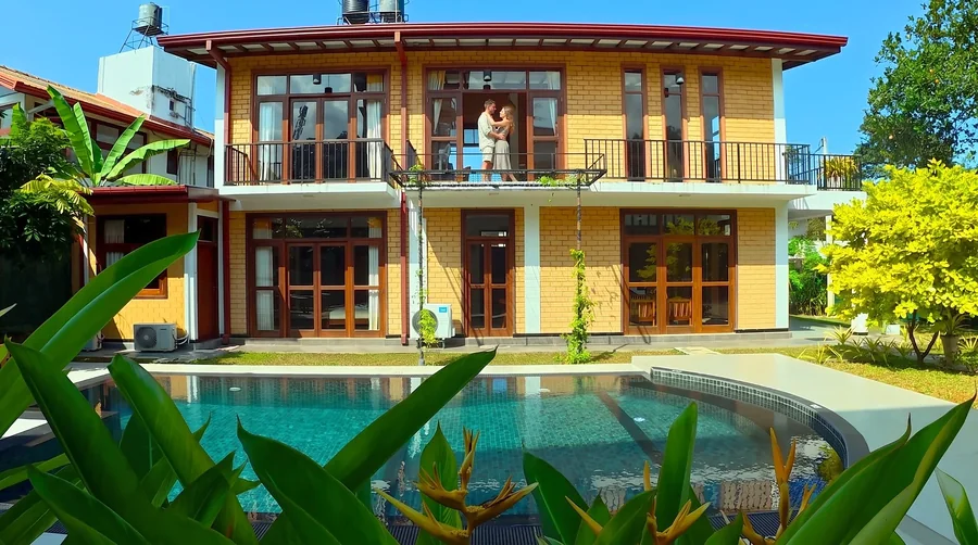 The villa and private pool, with a couple on the upstairs balcony — Syndeo Garden, Hikkaduwa