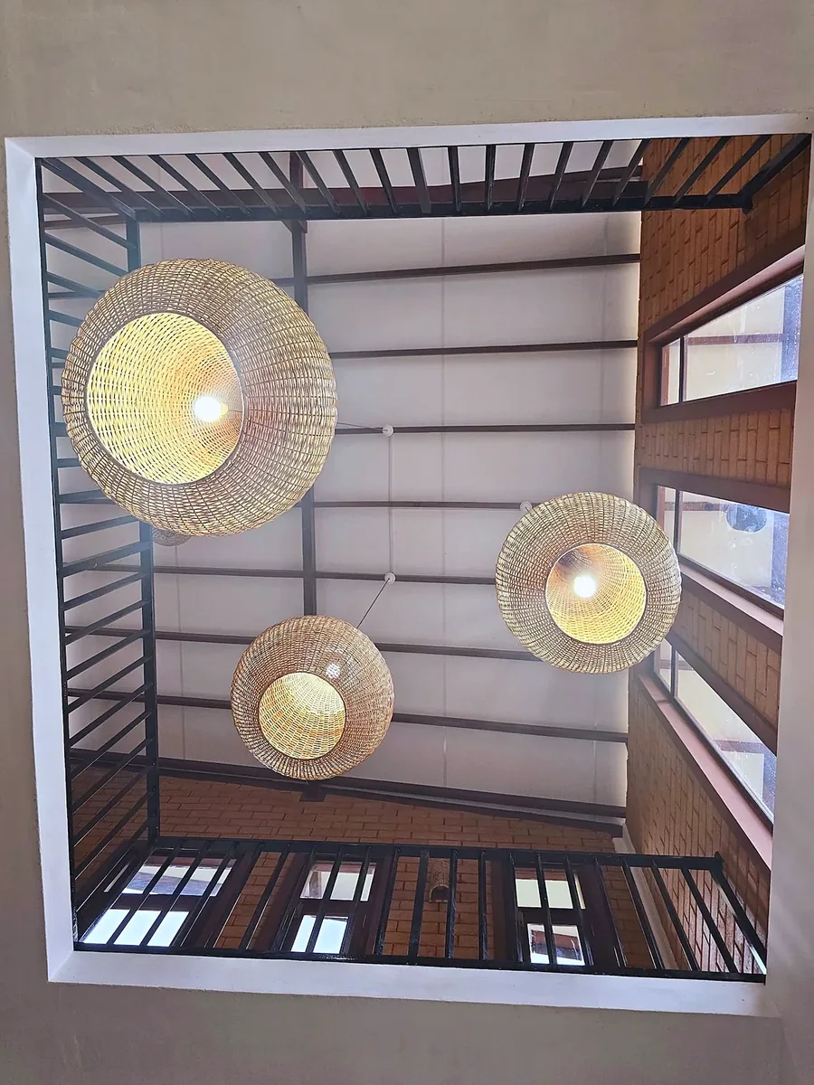 Woven lights beneath a timber ceiling — Syndeo Garden, Hikkaduwa